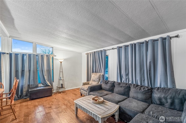 living area with wood-type flooring, a textured ceiling, and lofted ceiling