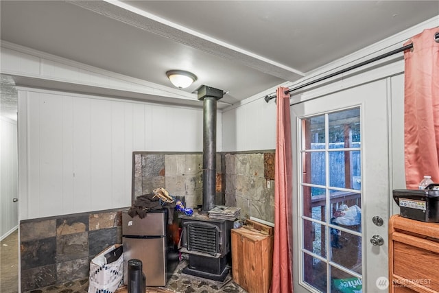 interior space featuring a wood stove and freestanding refrigerator