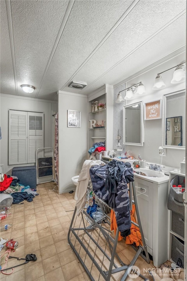 bathroom featuring visible vents, toilet, vanity, a shower with curtain, and a textured ceiling