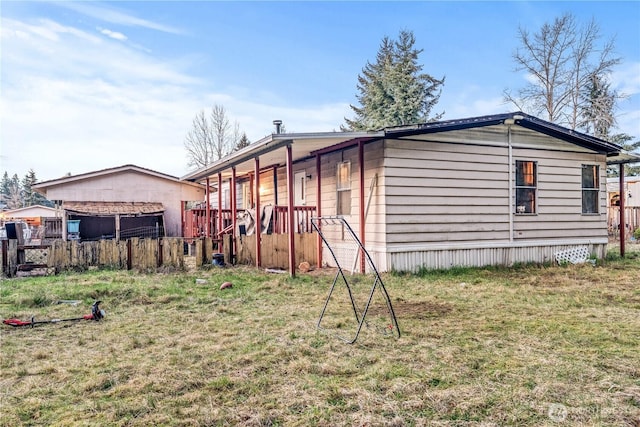 view of home's exterior with a lawn and fence