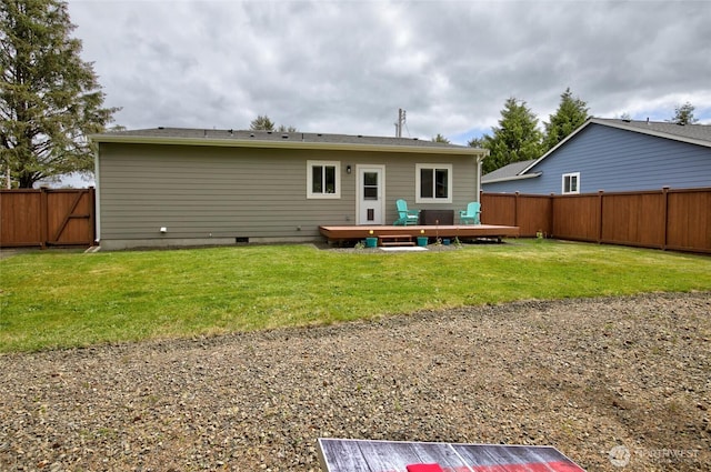 rear view of property with crawl space, a fenced backyard, a yard, and a deck