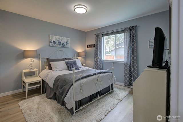 bedroom featuring baseboards and wood finished floors