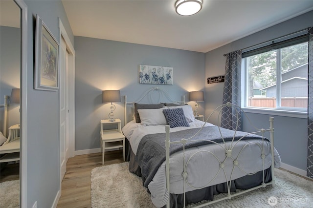 bedroom featuring baseboards and wood finished floors