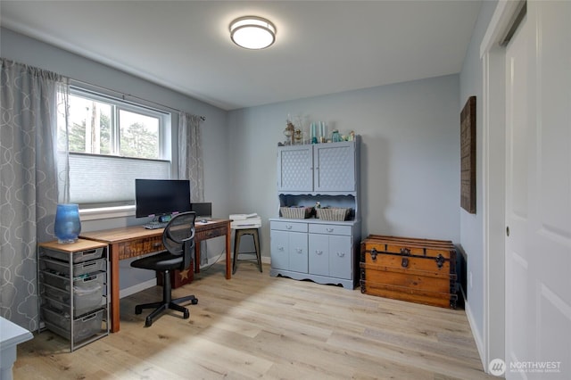 office space with light wood-type flooring and baseboards