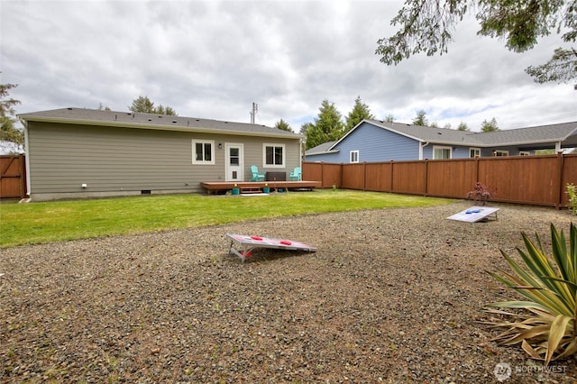 back of house featuring crawl space, a wooden deck, fence, and a yard