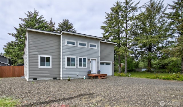 back of property with crawl space, fence, and driveway