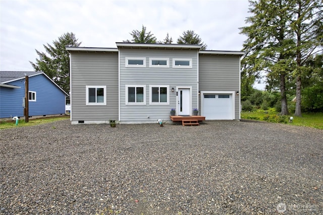 view of front of property with a garage and gravel driveway