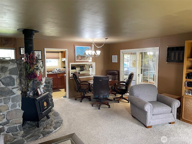 office featuring a wood stove, light carpet, and a notable chandelier