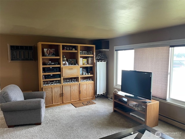 living area with carpet, a baseboard heating unit, and a wealth of natural light