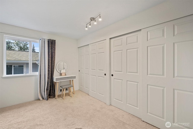 bedroom featuring carpet and multiple closets