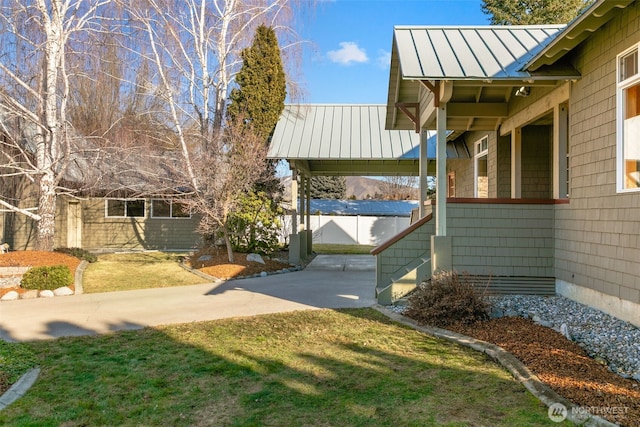 exterior space with a lawn, metal roof, and a standing seam roof