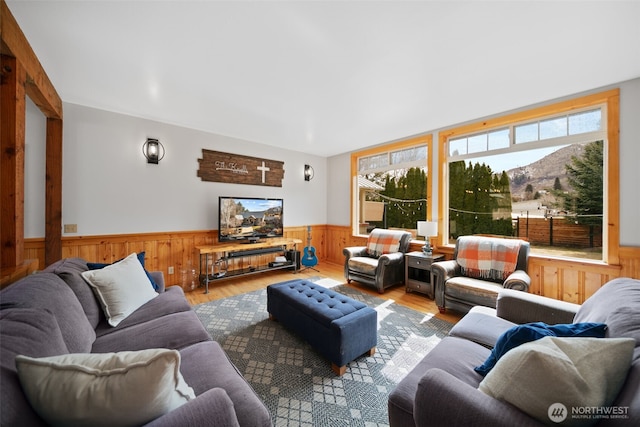 living area with wood finished floors and wainscoting