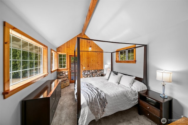 carpeted bedroom featuring multiple windows, wooden walls, and vaulted ceiling with beams