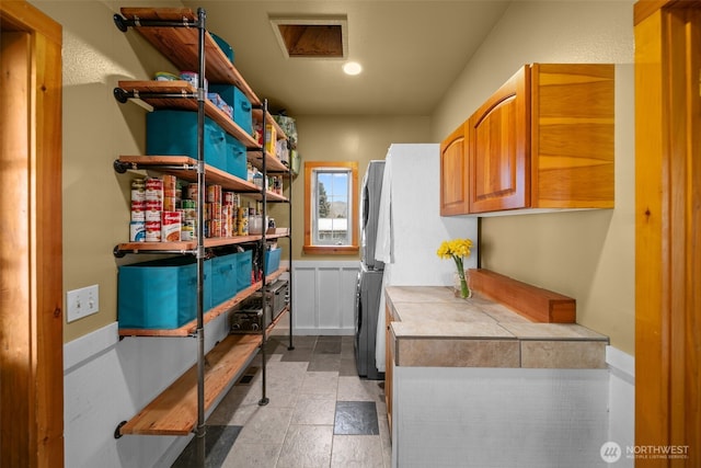 interior space with open shelves, tile countertops, and stone finish flooring