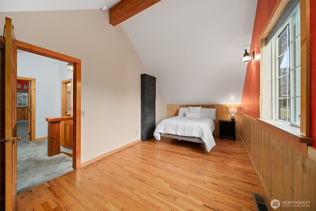 bedroom featuring vaulted ceiling with beams, visible vents, and light wood finished floors