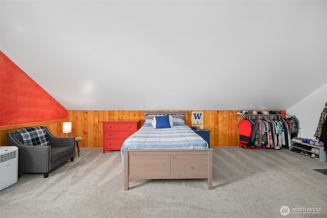 carpeted bedroom with wooden walls and vaulted ceiling