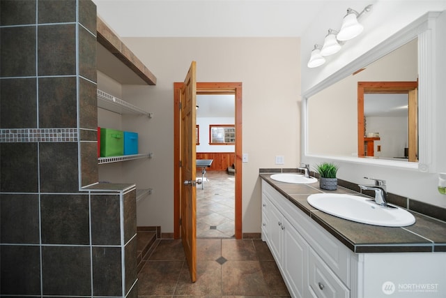 full bathroom featuring double vanity, tile patterned flooring, and a sink