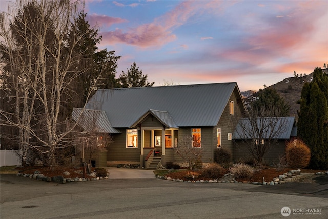 view of front of house featuring aphalt driveway, metal roof, and a mountain view