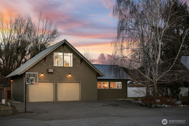 view of front facade featuring aphalt driveway, a garage, metal roof, and a standing seam roof