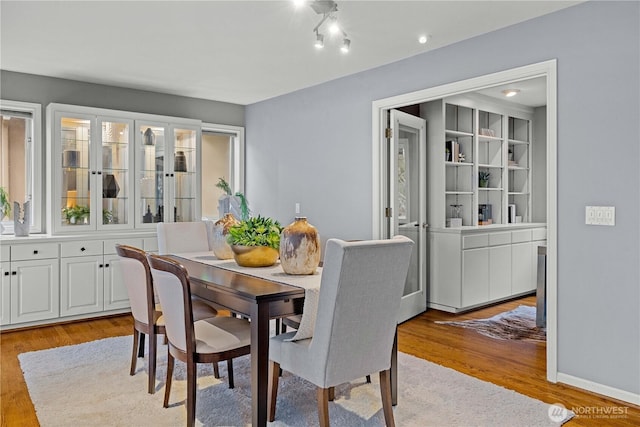 dining area featuring light wood-type flooring and baseboards