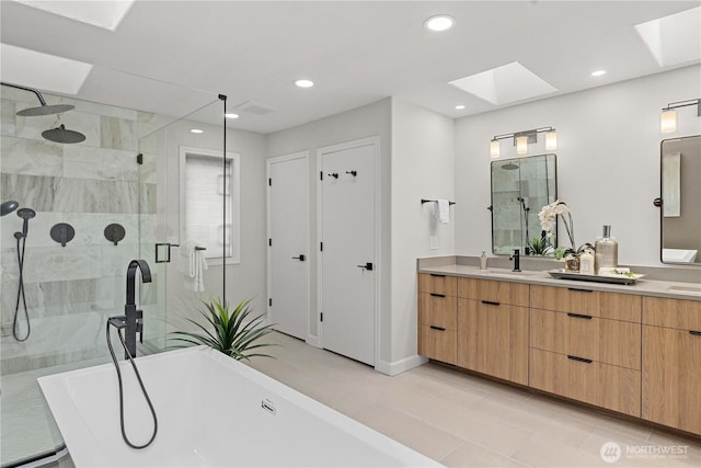 bathroom with a sink, double vanity, a freestanding tub, and a shower stall