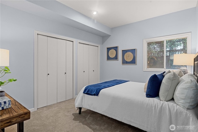 carpeted bedroom featuring multiple closets