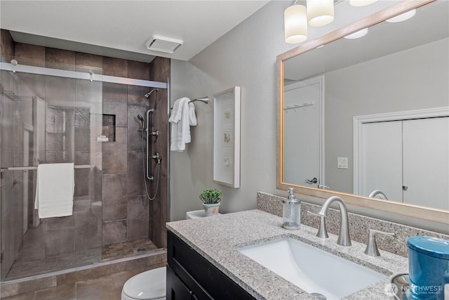 full bathroom with vanity, a shower stall, and toilet