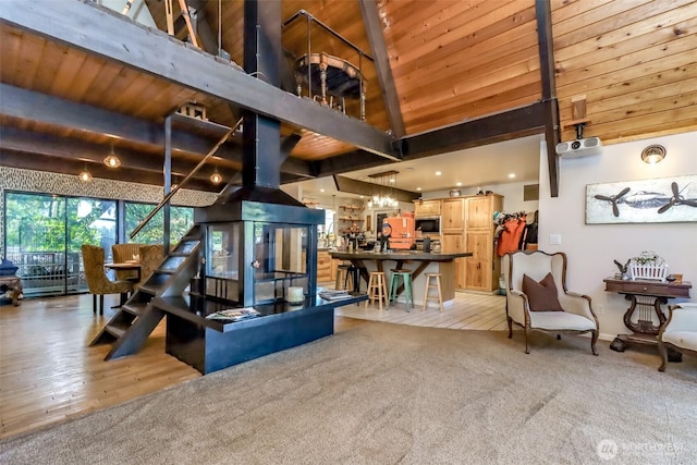 living area featuring light carpet, high vaulted ceiling, beamed ceiling, and wood ceiling