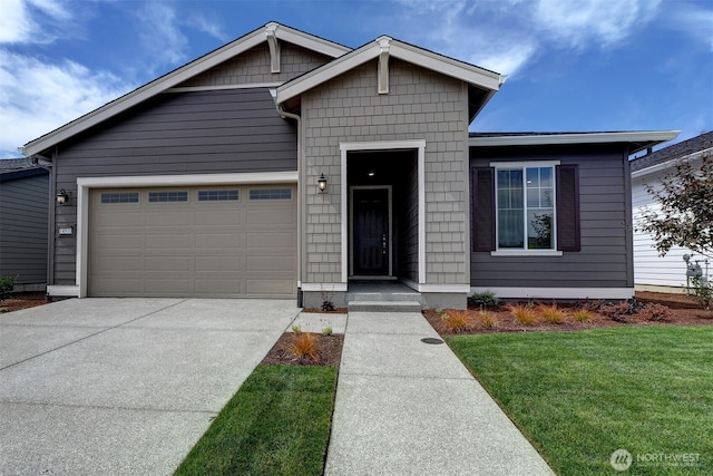 view of front of home featuring a garage, driveway, and a front yard