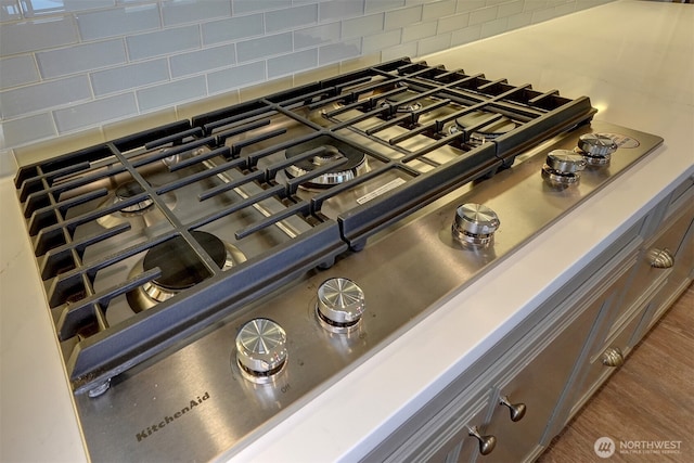 details featuring stainless steel gas cooktop and tasteful backsplash