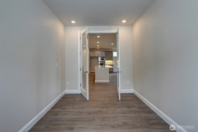 interior space featuring recessed lighting, dark wood finished floors, and baseboards