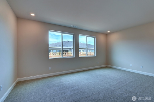 spare room with carpet floors, recessed lighting, visible vents, and baseboards