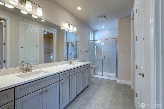 bathroom with double vanity, a stall shower, visible vents, and a sink