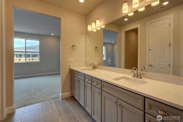 full bath featuring double vanity, a sink, visible vents, and tile patterned floors