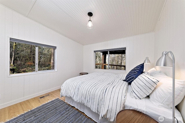 471 SE Old Arcadia Rd, Shelton, WA 98584 - bedroom with wood finished floors, vaulted ceiling, multiple windows, and baseboards