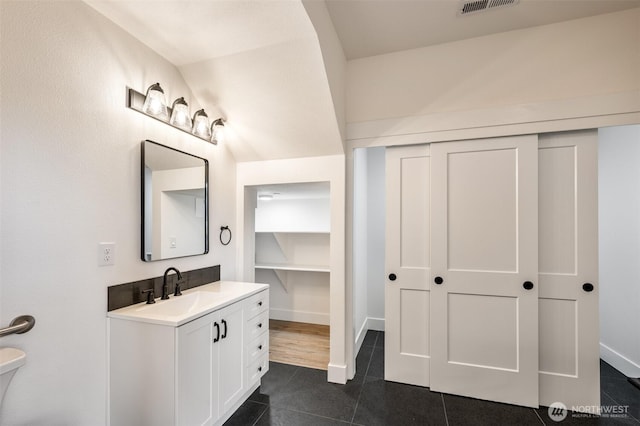 bathroom with toilet, vanity, baseboards, and tile patterned floors