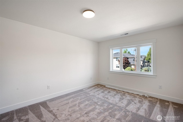 unfurnished room featuring carpet, visible vents, and baseboards