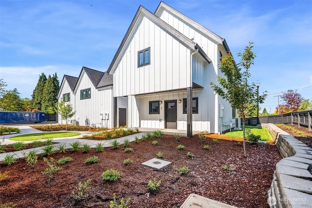 modern farmhouse with fence and board and batten siding