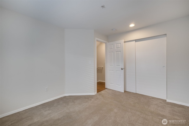 unfurnished bedroom featuring baseboards, a closet, carpet flooring, and recessed lighting