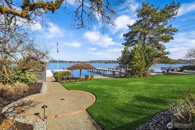 exterior space with a yard, a water view, and a boat dock