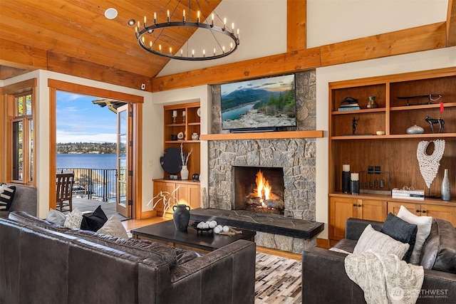 living room with built in shelves, lofted ceiling, a stone fireplace, and wood finished floors