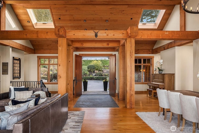 living room with lofted ceiling with skylight and light wood-style floors