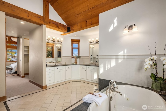 full bathroom with lofted ceiling, double vanity, a whirlpool tub, tile patterned floors, and a sink