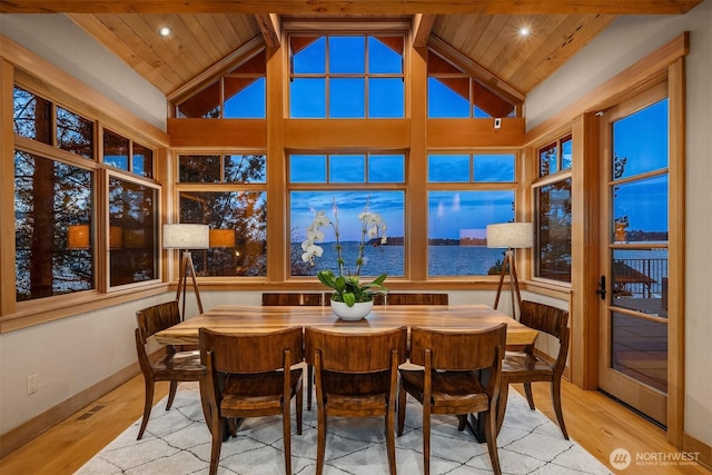 sunroom / solarium with lofted ceiling with beams, wood ceiling, and a water view