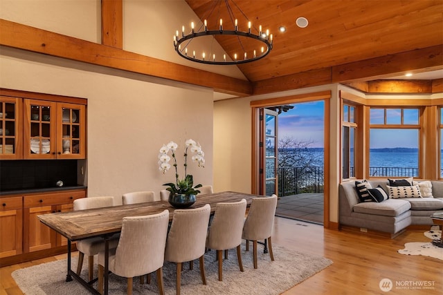 dining room with wood ceiling, an inviting chandelier, light wood-style flooring, and vaulted ceiling