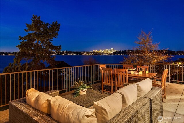 deck at twilight with a water view and an outdoor hangout area