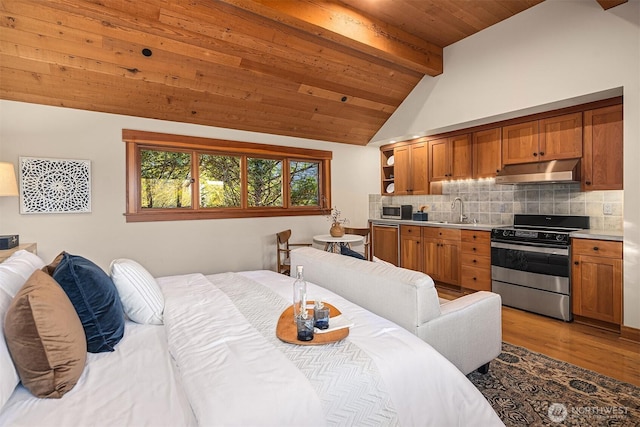 bedroom with wooden ceiling, vaulted ceiling with beams, light wood-style floors, and a sink