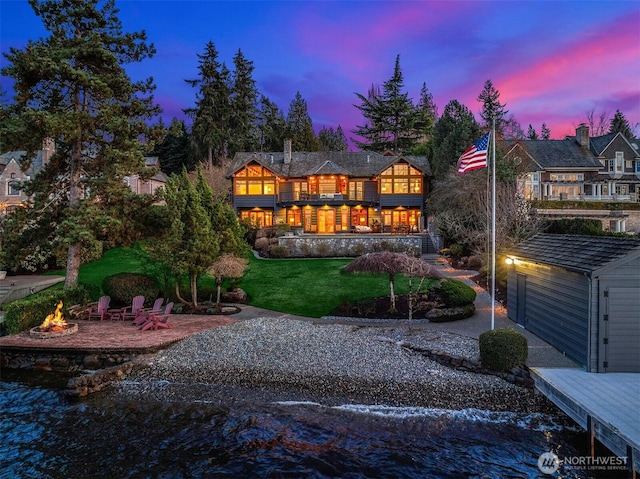 7010 N Mercer Way, Mercer Island, WA 98040 - back of property at dusk with an outdoor fire pit and a yard