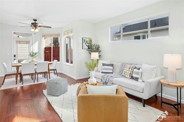 living room with dark wood-style flooring, ceiling fan, and baseboards