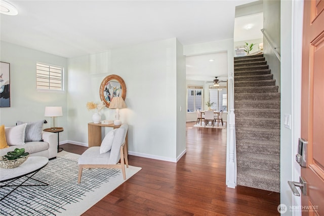 living area featuring stairs, baseboards, and wood finished floors